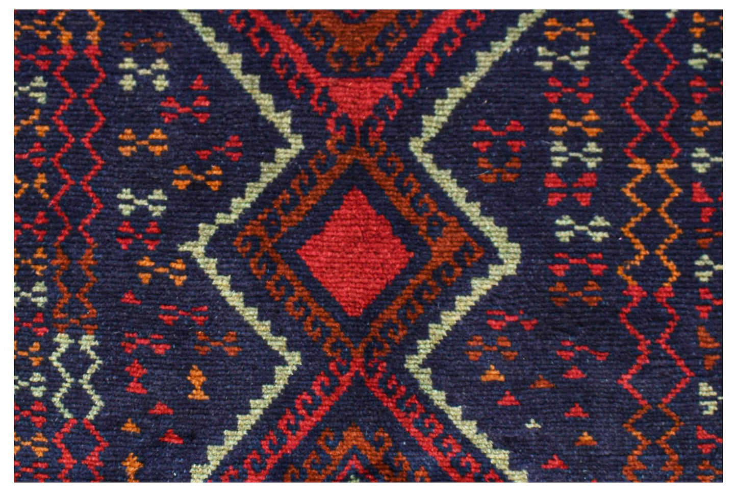 A handmade Afghan Pashm rug featuring a geometric diamond pattern in dark red, blue, and ivory.