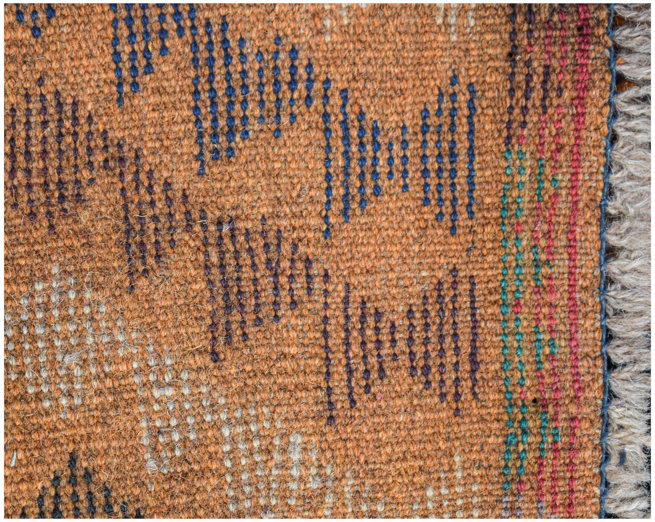 A handmade Afghan Pashm rug featuring a geometric pattern in blue, brown, and ivory wool.