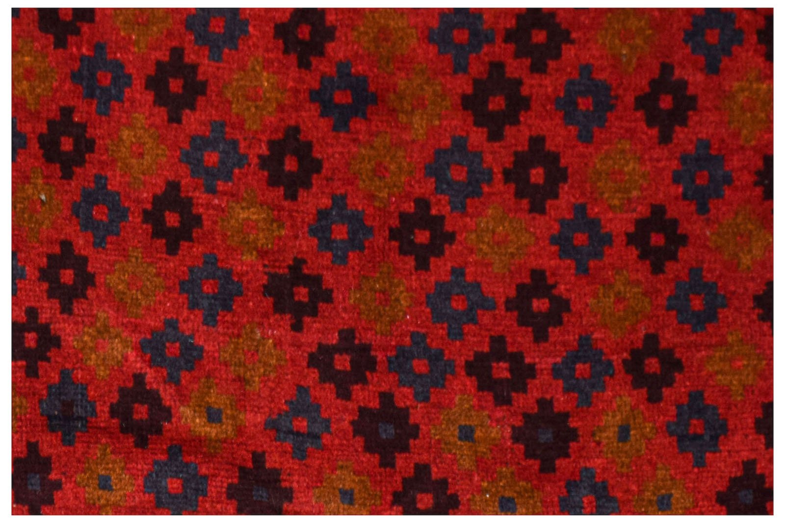 A handmade Afghan Pashm rug featuring a repeating geometric pattern in dark red, blue, and brown.