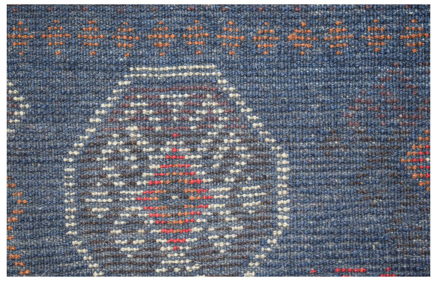 Handmade Afghan Pashm rug featuring a dark blue wool base with geometric ivory and red patterns.