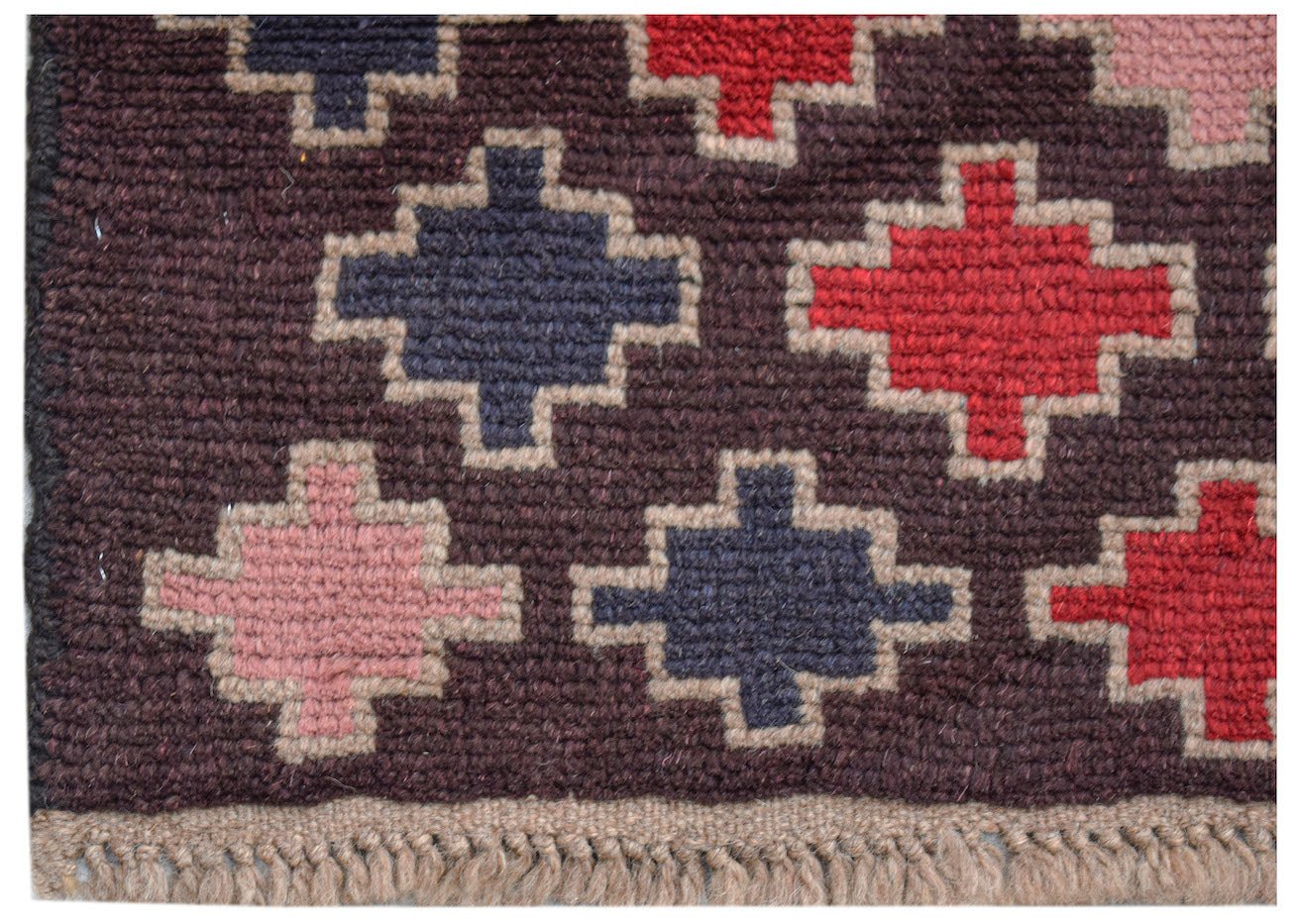 Handmade Afghan Pashm rug featuring a dark brown background with geometric cross motifs in red and blue.