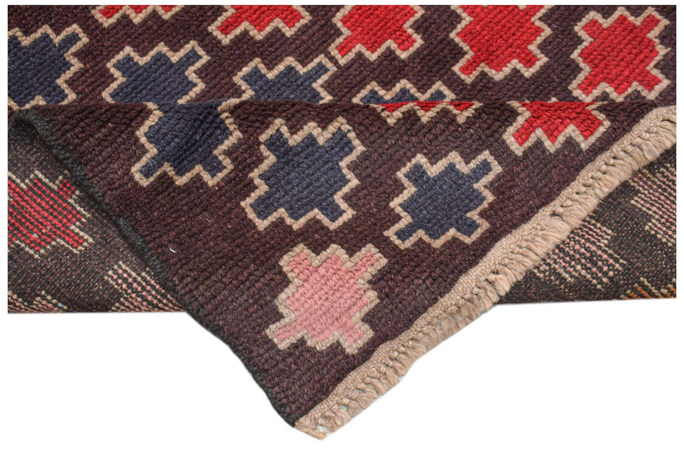 A handmade Afghan Pashm rug featuring a geometric pattern in dark red, blue, and pink on brown.