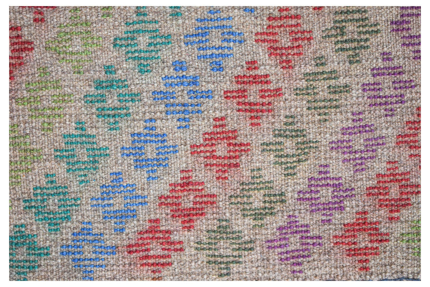 Handmade Afghan Pashm rug featuring a repeating geometric diamond pattern in vibrant colors.