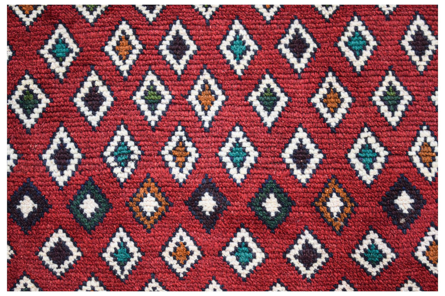 Handmade Afghan Pashm rug featuring a repeating diamond pattern in red, ivory, blue, and brown.