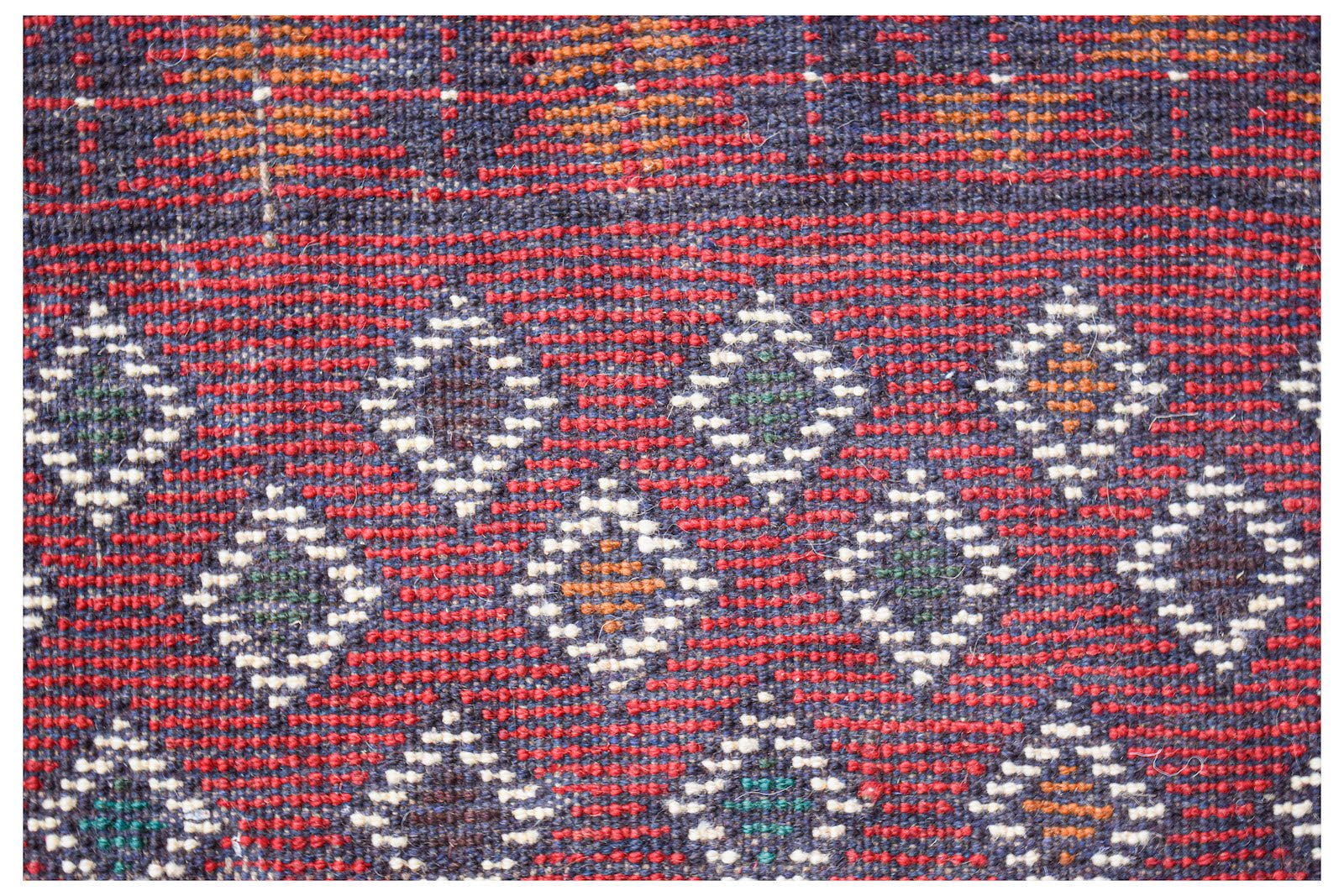 Handmade Afghan Pashm rug featuring a geometric diamond pattern in red, blue, and ivory wool.