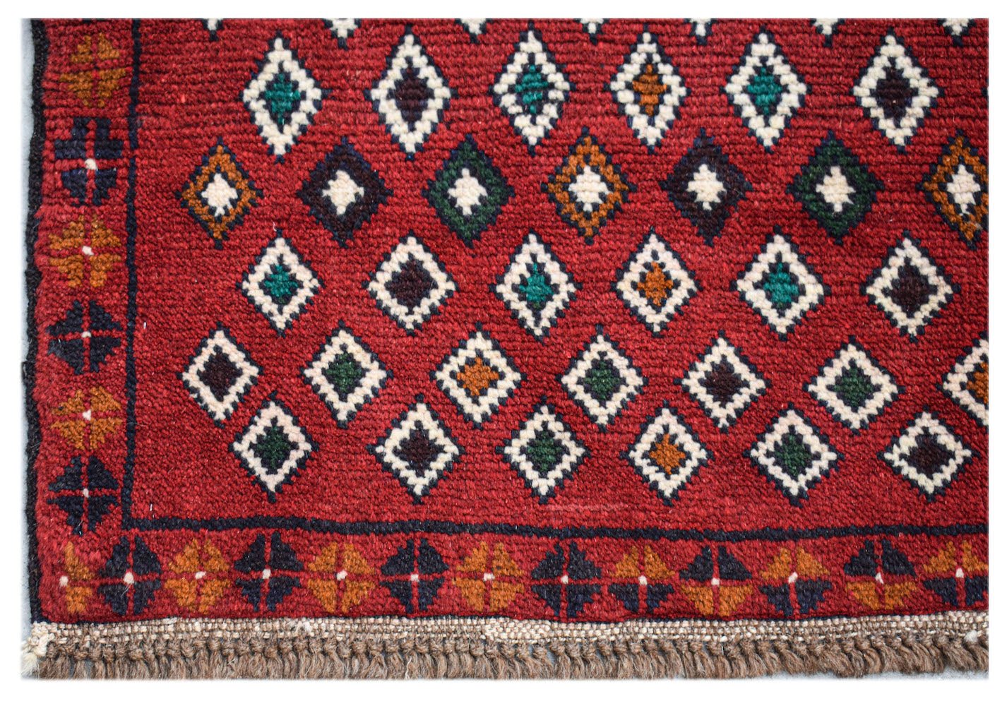 Handmade Afghan Pashm rug featuring a geometric diamond pattern in red, blue, and ivory wool.