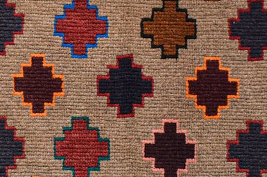 Handmade Afghan Pashm rug featuring a repeating pattern of colorful geometric cross motifs.