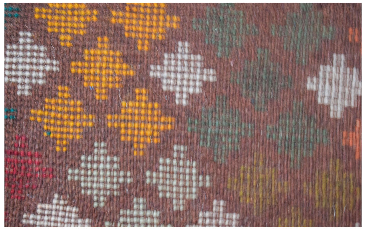 Handmade Afghan Pashm rug featuring a repeating geometric diamond pattern in earthy tones.