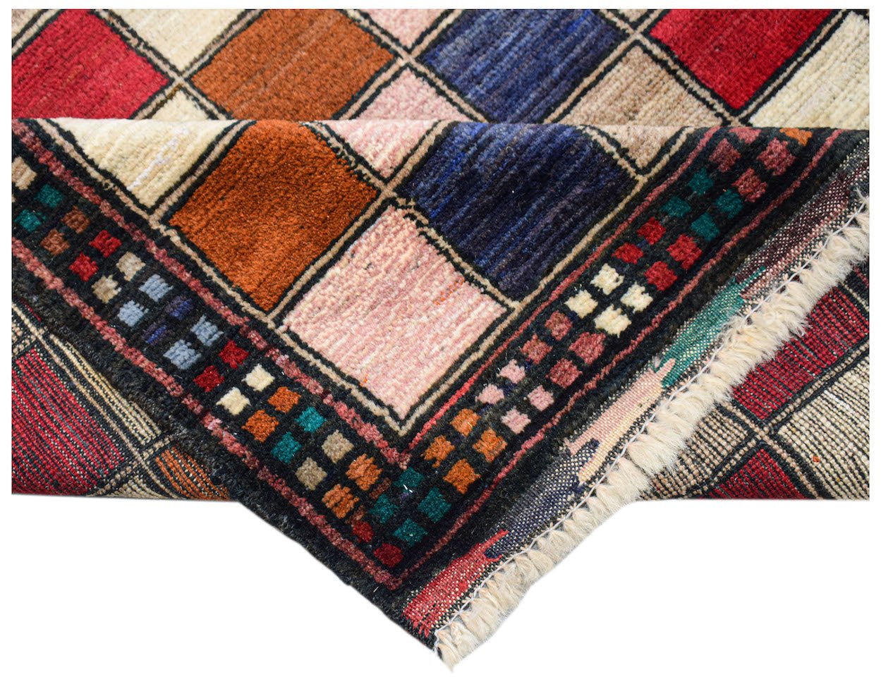 Handmade Afghan Pashm rug featuring a colorful geometric grid pattern with a fringed edge.