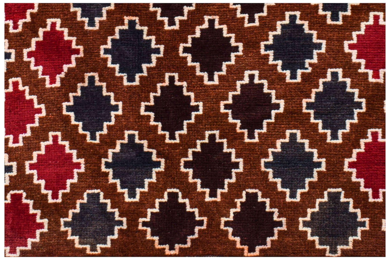 Handmade Afghan Pashm rug featuring a repeating geometric pattern in dark red, brown, and blue.