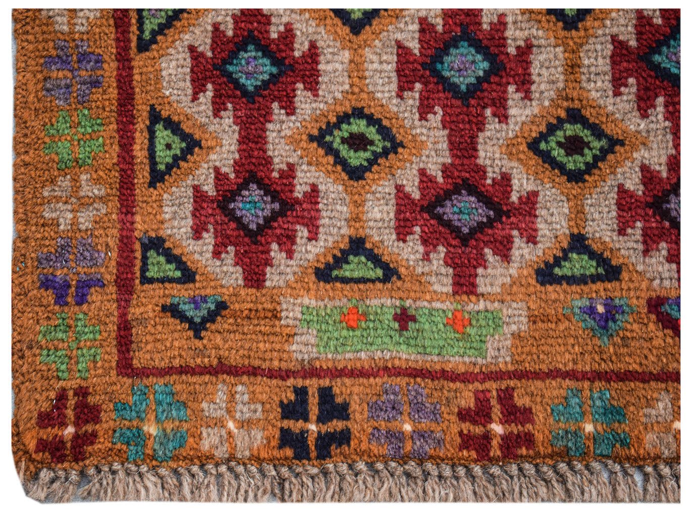 Handmade Afghan Pashm rug featuring a geometric tribal pattern in red, blue, and brown wool.
