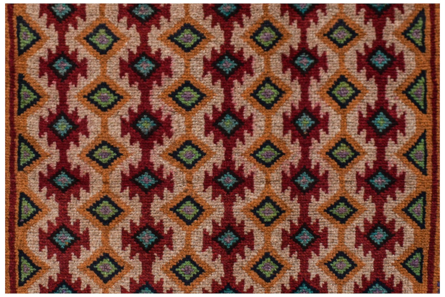 Handmade Afghan Pashm rug featuring a repeating geometric diamond pattern in red, orange, and blue.