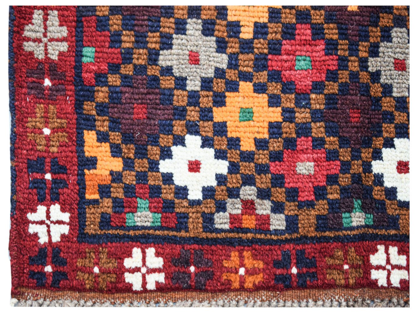 Handmade Afghan Pashm rug featuring a geometric floral pattern in red, blue, and ivory wool.
