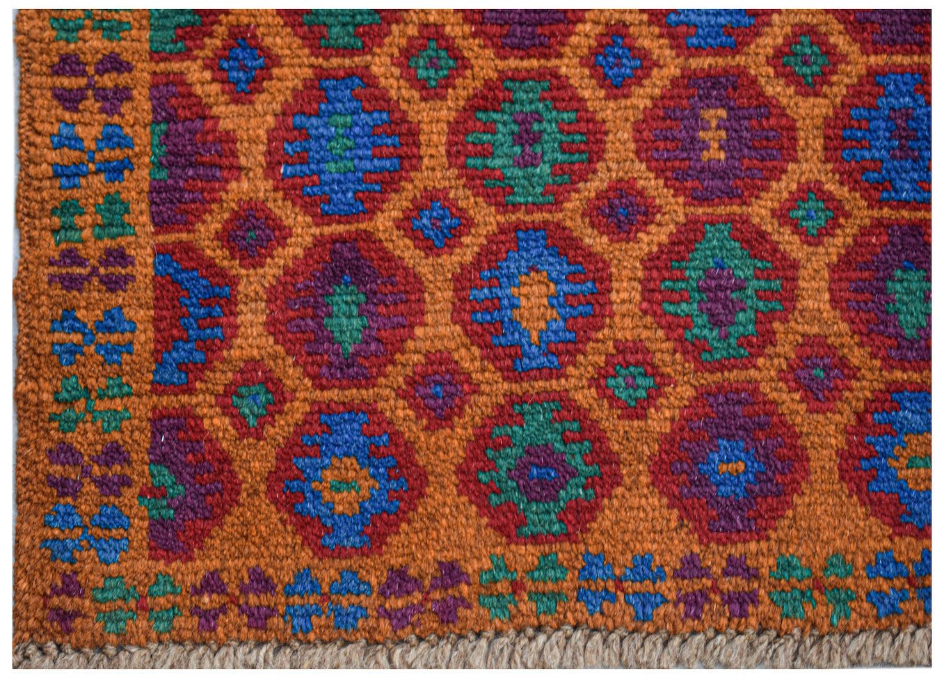 A handmade Afghan Pashm rug featuring a geometric tribal pattern in orange, blue, red, and green.