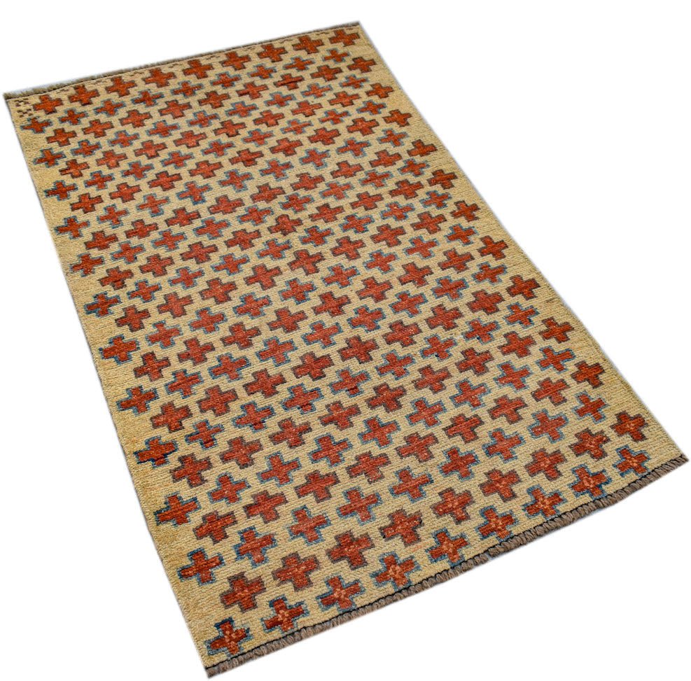 Handmade Afghan Pashm rug featuring a repeating red and blue cross pattern on an ivory wool field.