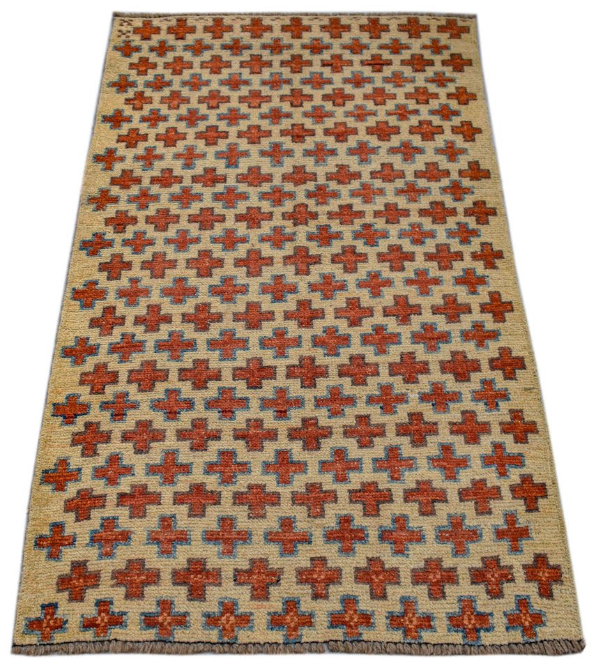 Handmade Afghan Pashm rug featuring a repeating pattern of orange and blue crosses on an ivory field.