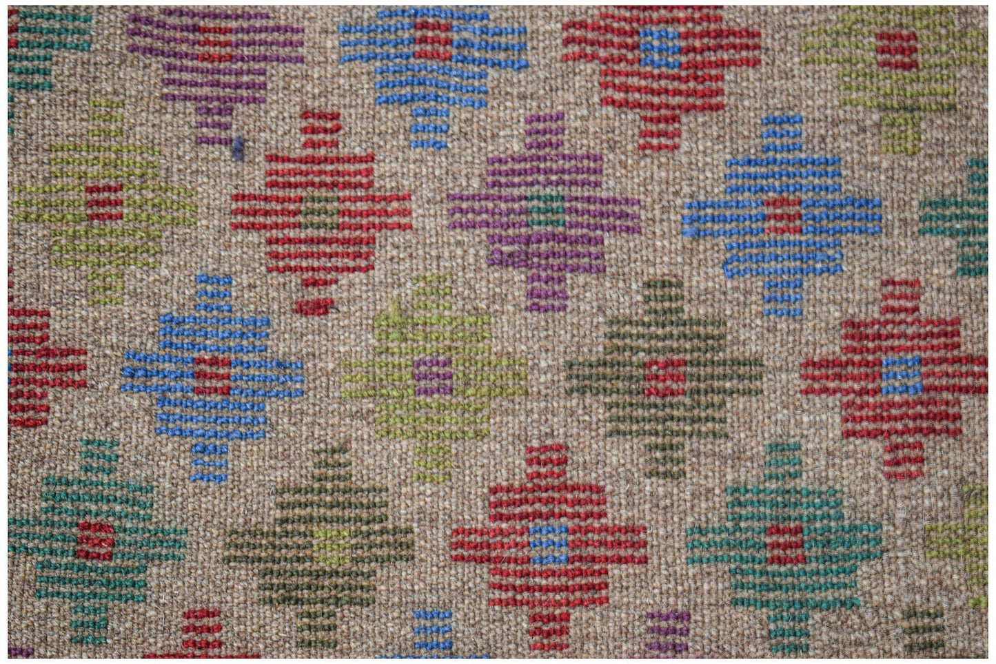 Handmade Afghan Pashm rug featuring a repeating geometric pattern in vibrant multi-colored wool.