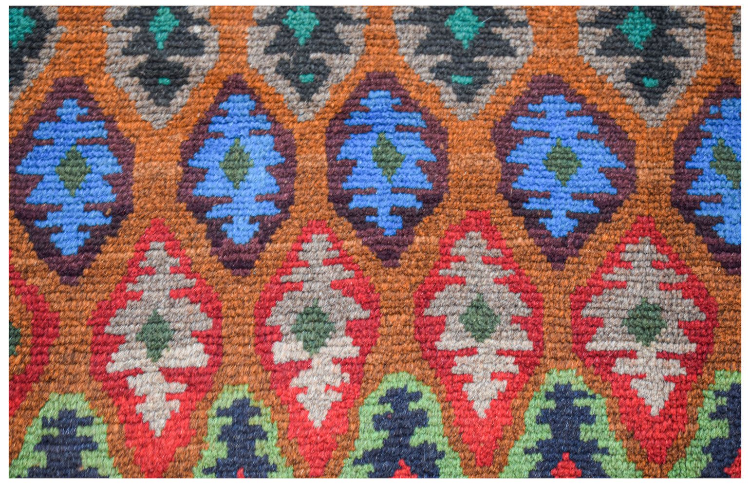 Handmade Afghan wool rug featuring a repeating diamond pattern in blue, red, and green tones.