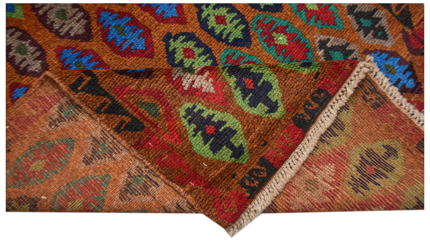 Handmade Afghan Pashm rug featuring a tribal geometric pattern in shades of red, blue, and brown.