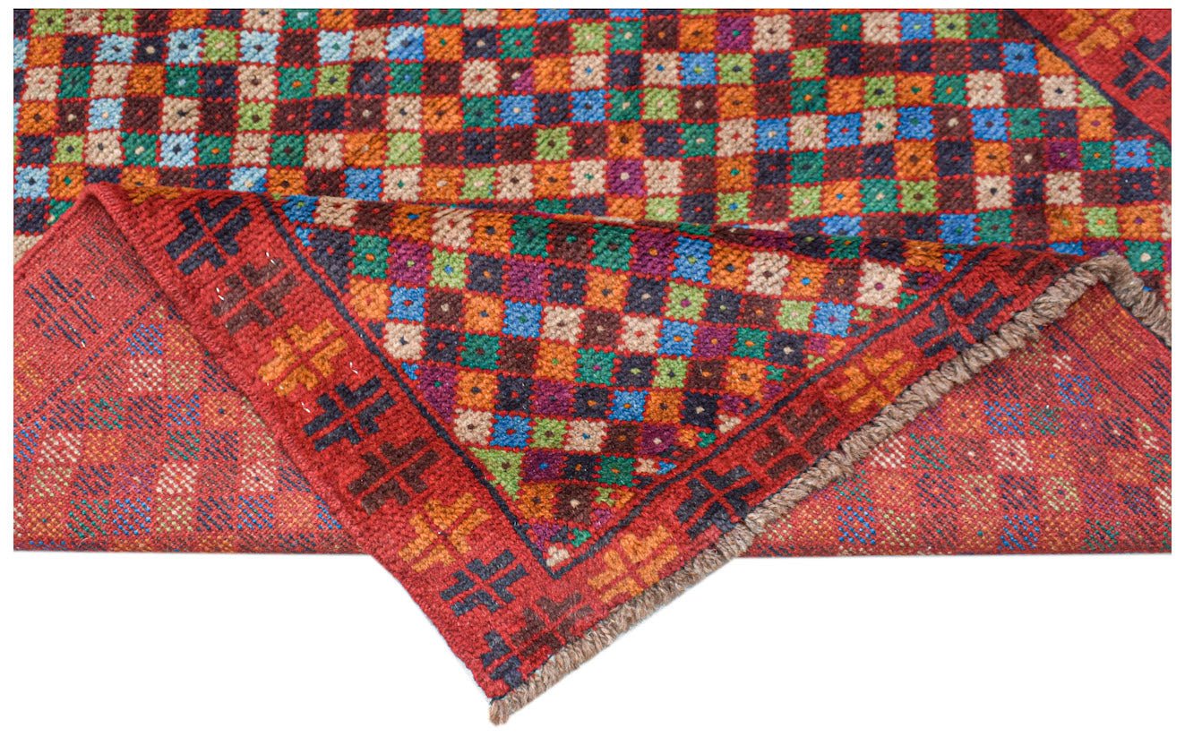 A handmade Afghan Pashm rug featuring a vibrant, multi-colored checkered pattern on a red base.