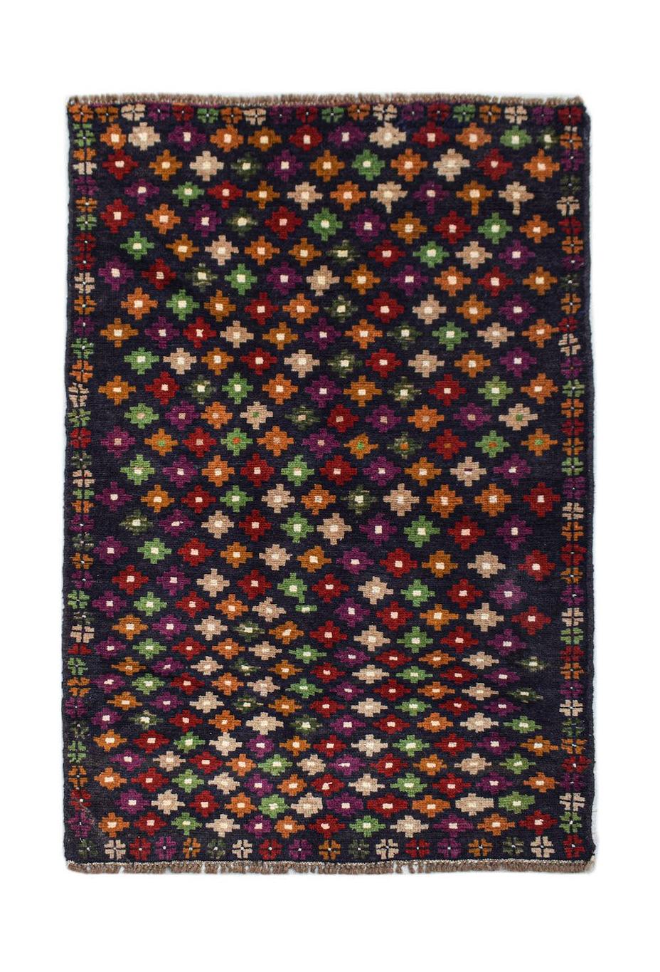 Handmade Afghan Pashm rug featuring a dark field with a repeating multicolored geometric pattern.