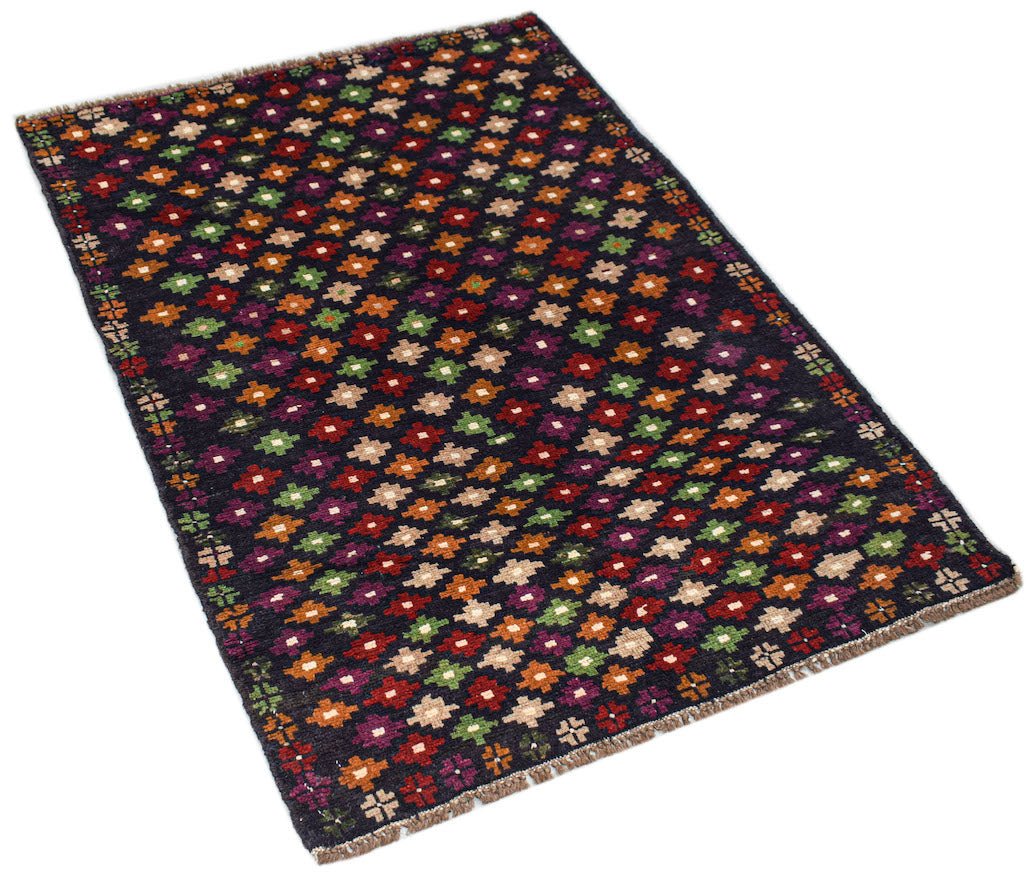 A handmade Afghan Pashm rug featuring a dark background with a repeating pattern of colorful floral motifs.