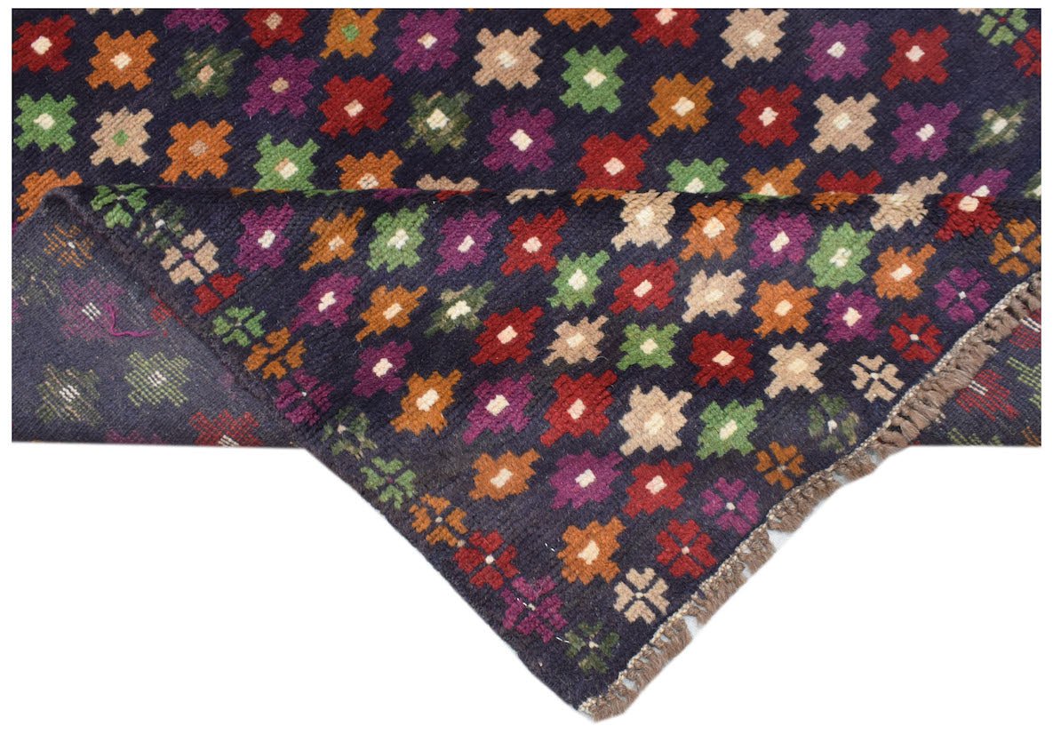 Handmade Afghan wool rug featuring a dark blue field with a repeating pattern of colorful motifs.