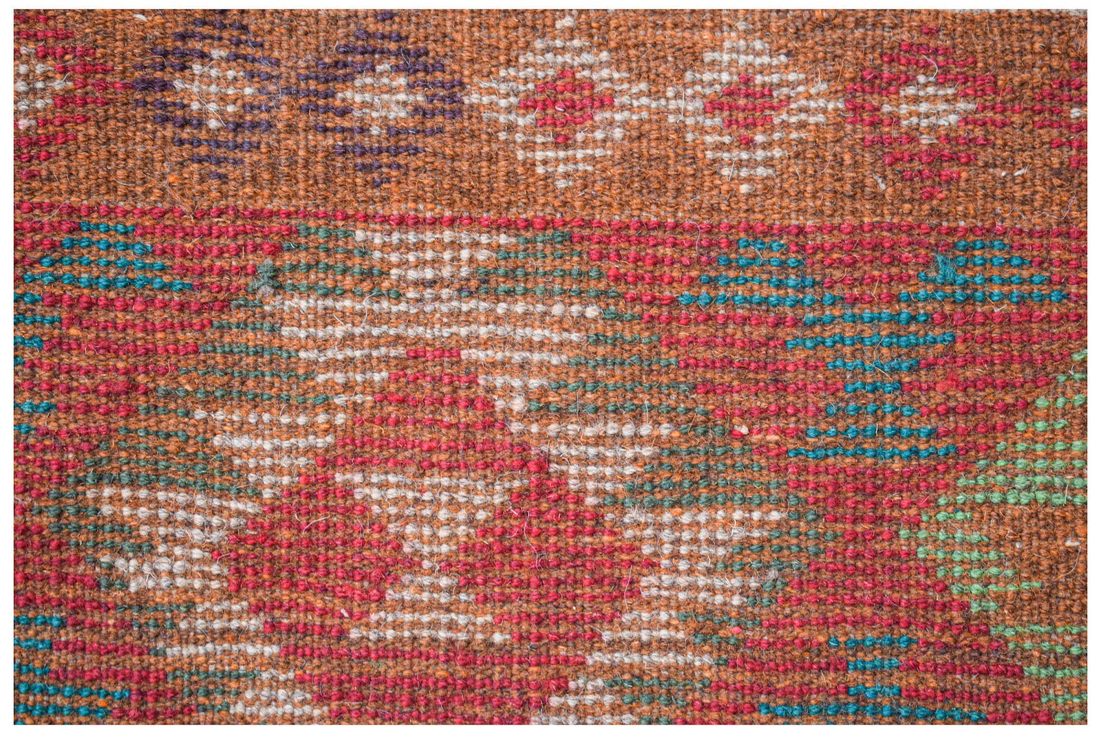 Handmade Afghan Pashm rug featuring a tribal geometric pattern in red, brown, blue, and ivory.