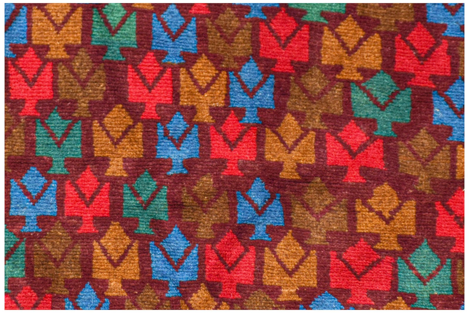 Handmade Afghan Pashm rug featuring a repeating geometric tree pattern in red, blue, and brown.