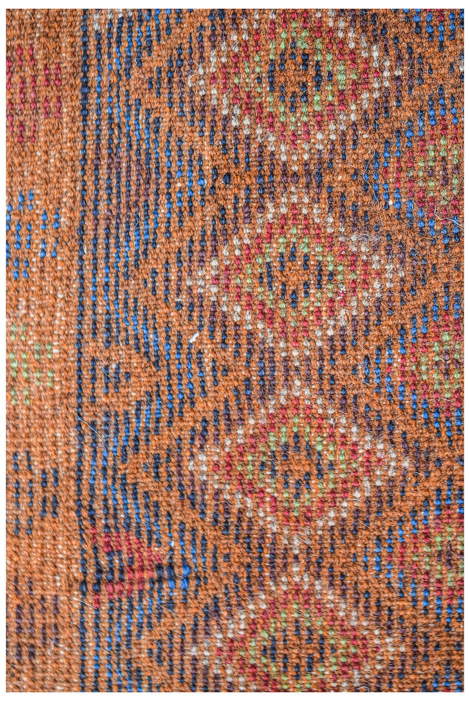 Handmade Afghan Pashm rug featuring a tribal pattern in shades of orange, blue, and red.