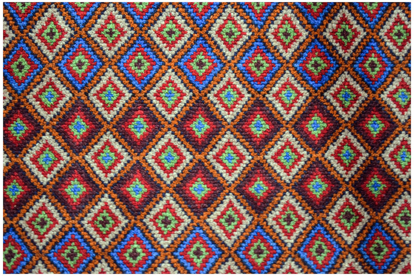 Handmade Afghan Pashm rug featuring a repeating diamond pattern in red, blue, and ivory wool.