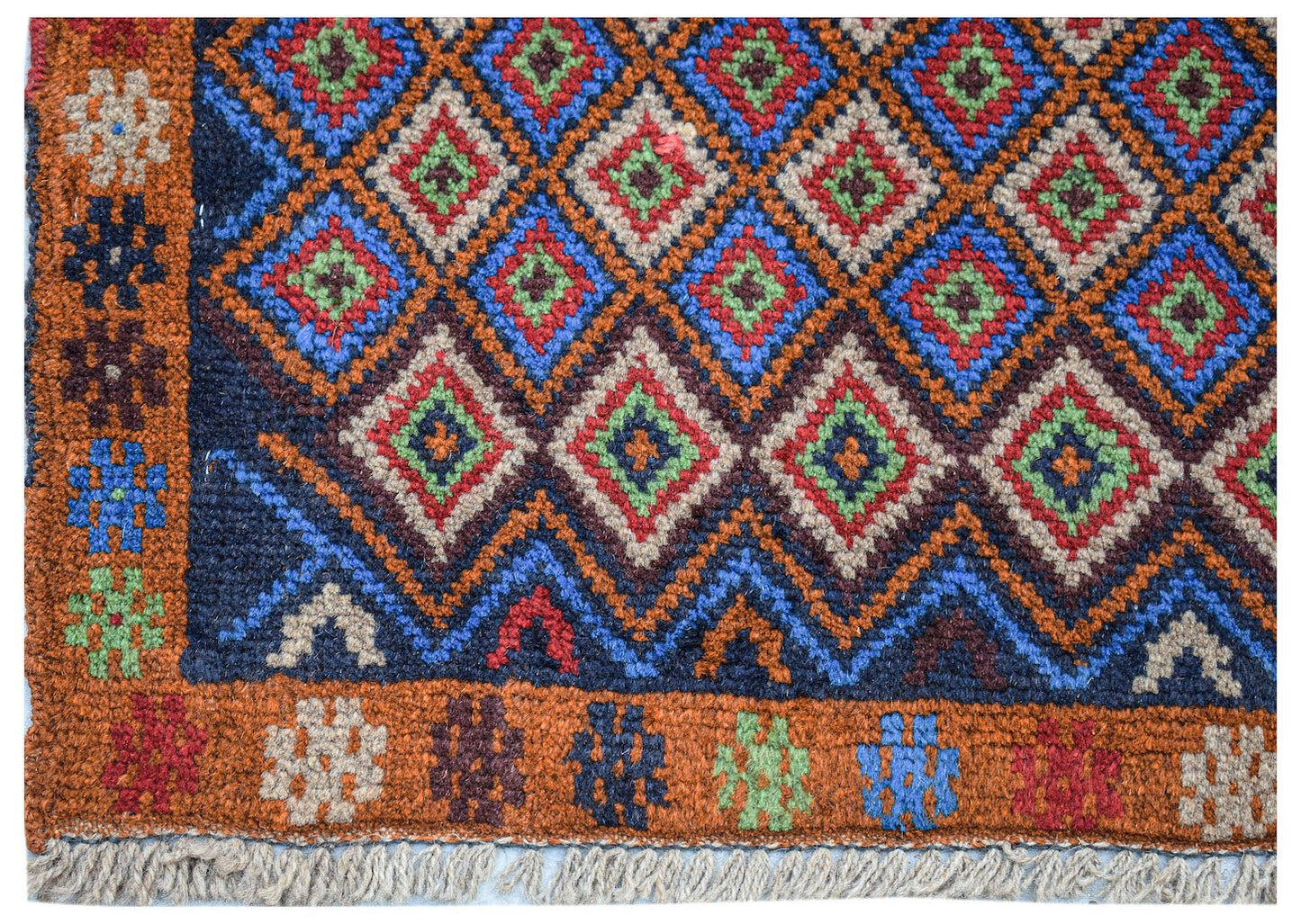 Handmade Afghan Pashm rug featuring a geometric diamond pattern in blue, red, and ivory wool.
