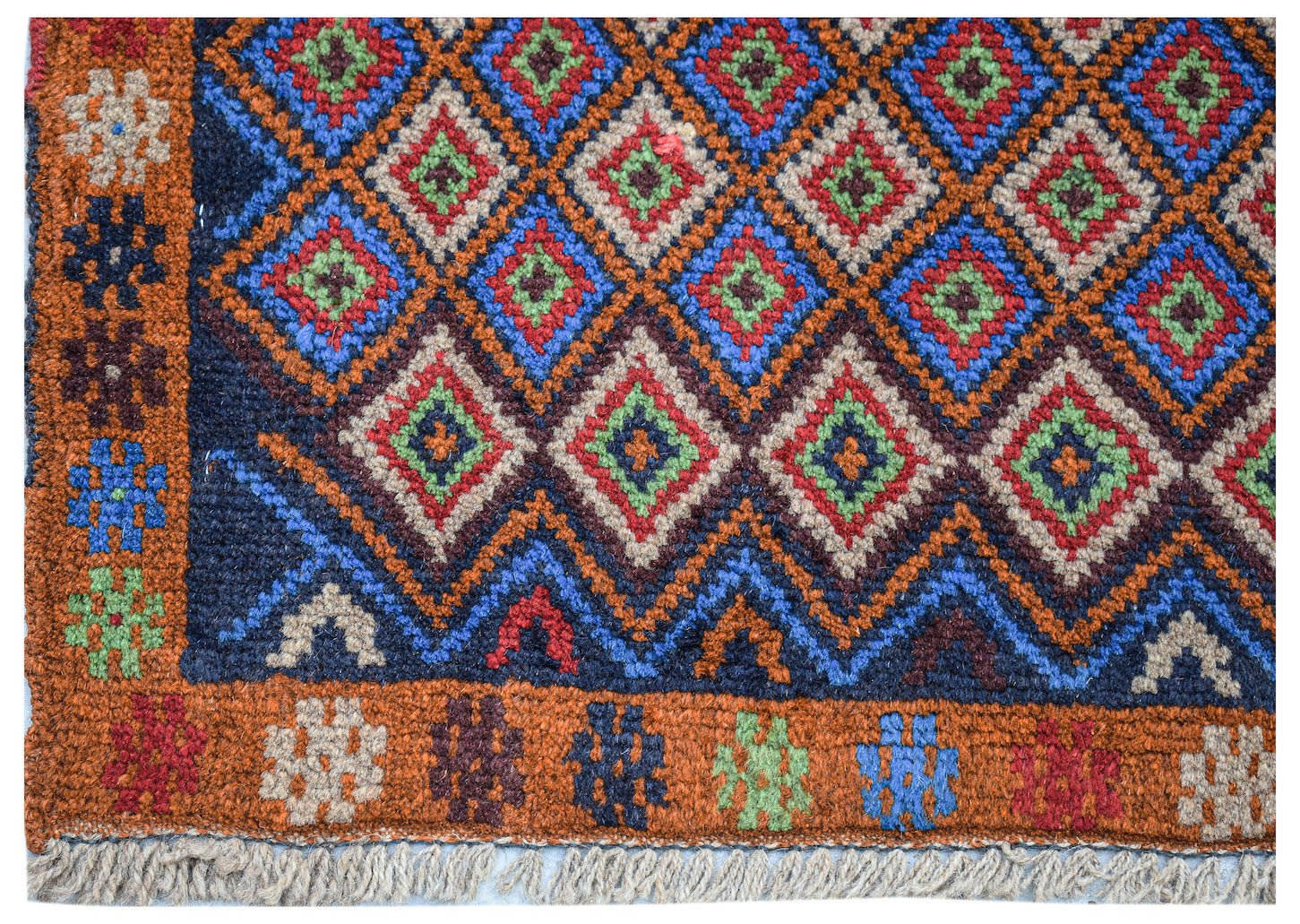 Handmade Afghan Pashm rug featuring a geometric diamond pattern in blue, red, and ivory wool.
