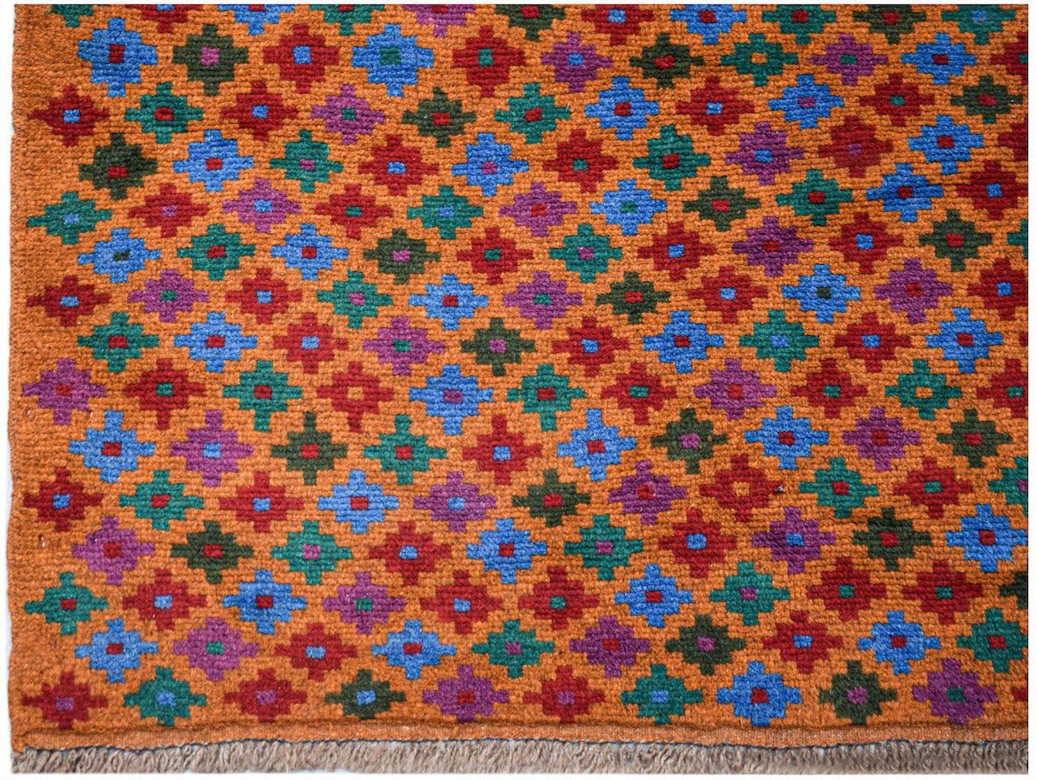 Handmade Afghan Pashm rug featuring a repeating geometric pattern in blue, red, green, and purple.