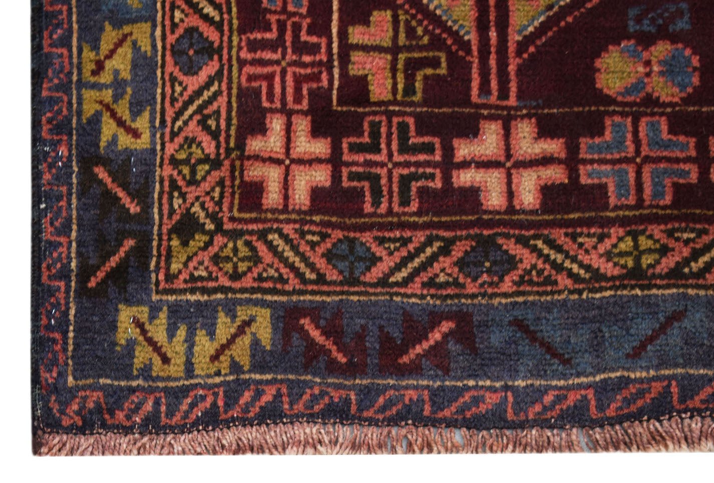 A handmade Afghan Pashm rug featuring geometric patterns in deep red, blue, and brown wool.