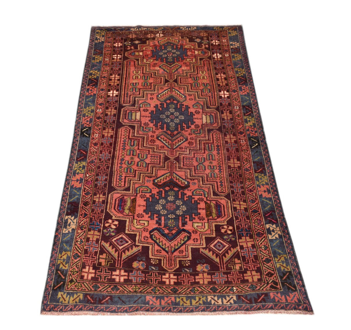 Handmade Afghan Pashm rug featuring a geometric tribal pattern in shades of red, blue, and brown.