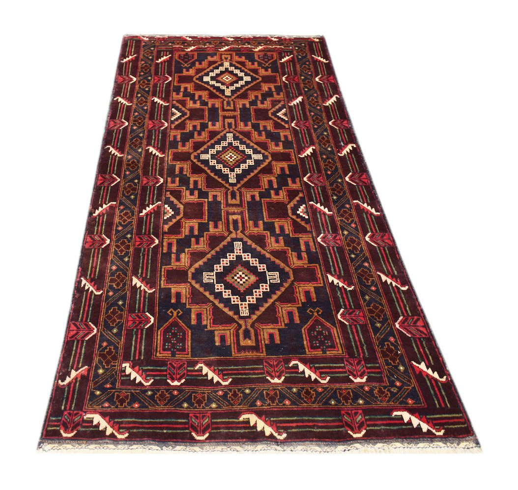 A handmade Afghan Pashm rug featuring geometric diamond patterns in dark red, brown, and ivory.