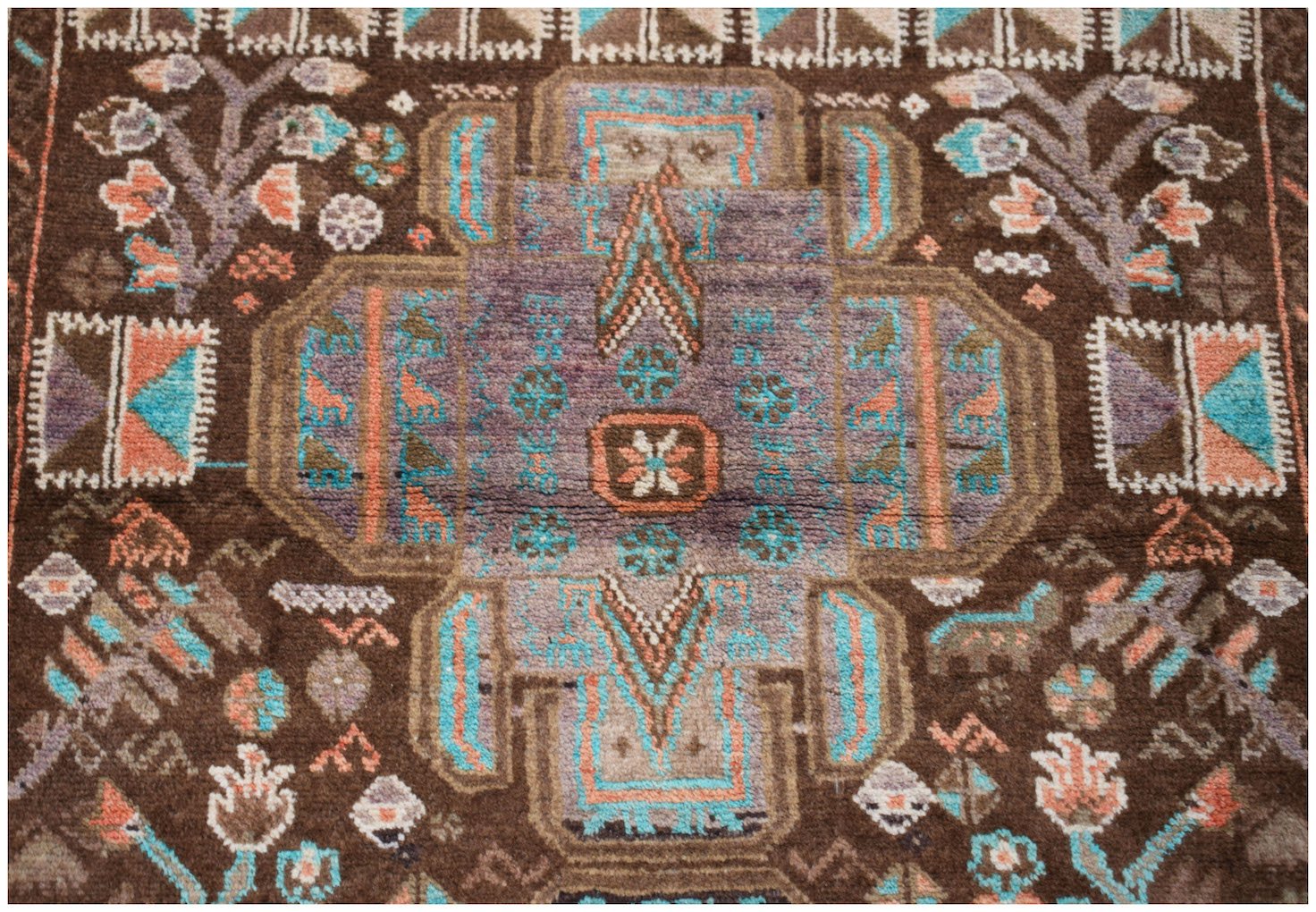 Handmade Afghan Pashm rug featuring a geometric tribal pattern in brown, blue, and orange tones.