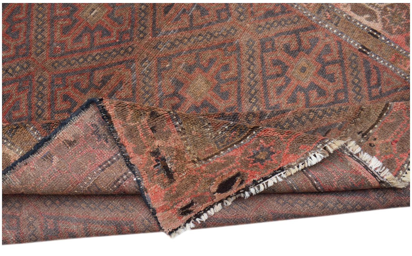A handmade Afghan Pashm rug featuring a geometric tribal pattern in shades of red, brown, and blue.