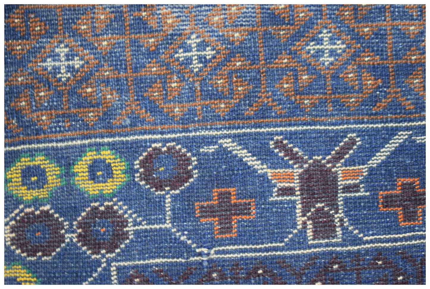 A handmade Afghan Pashm rug featuring intricate geometric and floral patterns in blue and brown.