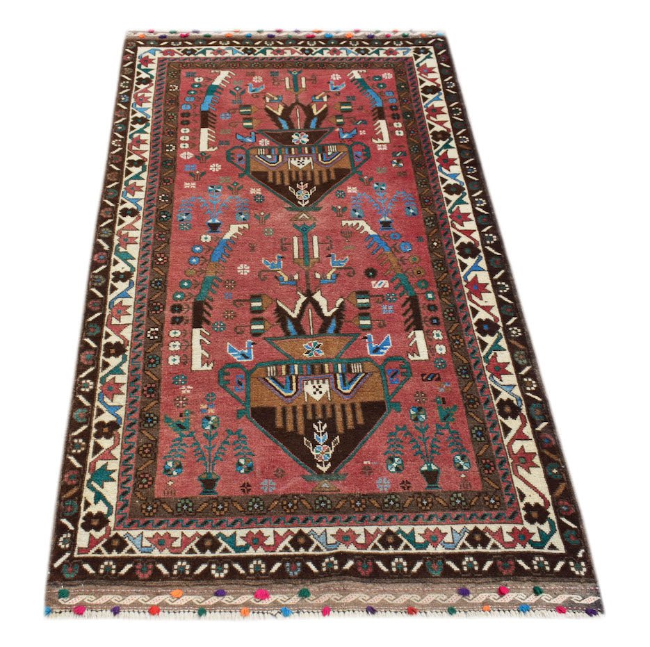 Handmade Afghan Pashm rug featuring a tribal vase motif in red, brown, and blue wool.
