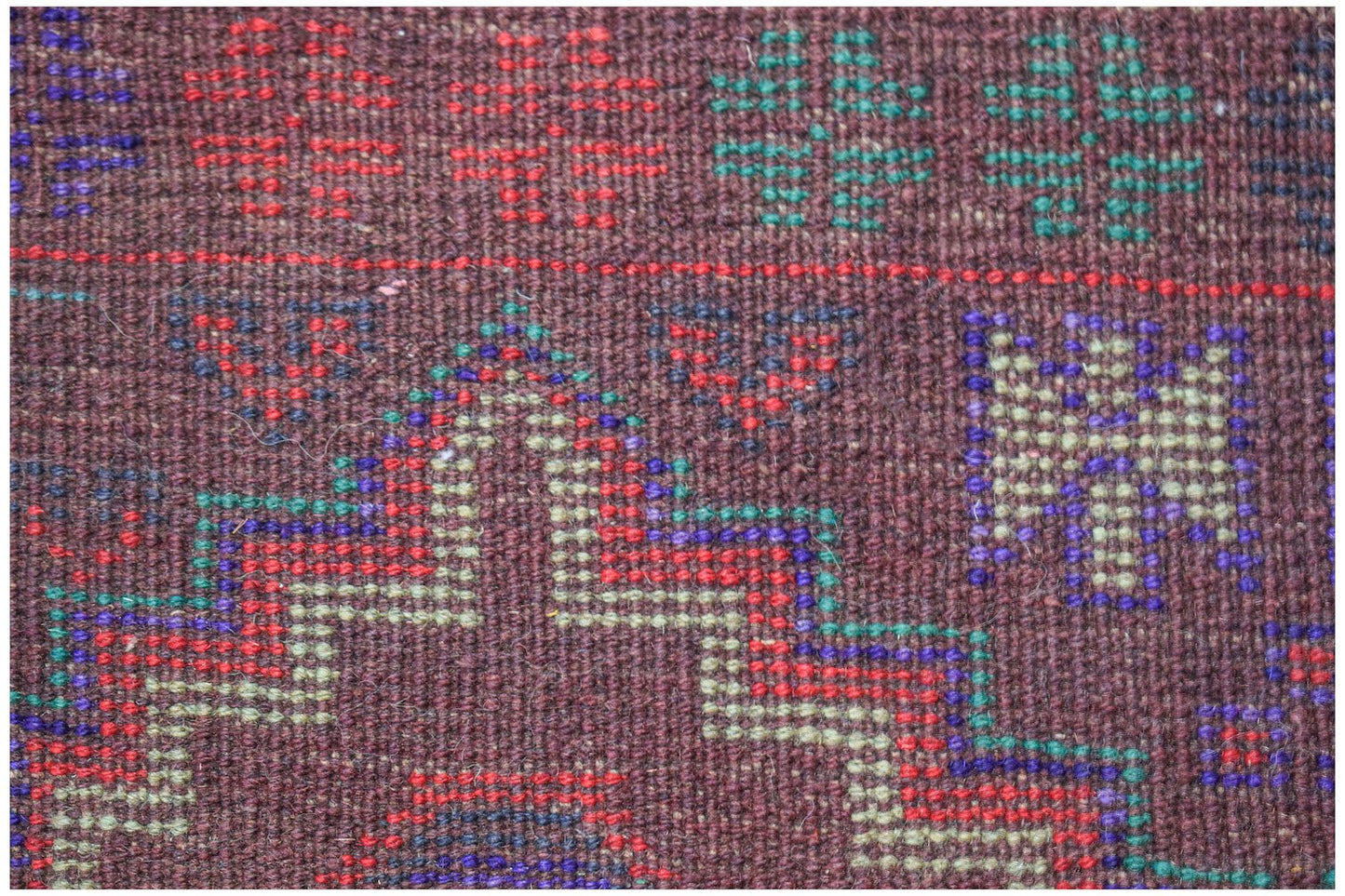 Handmade Afghan Pashm rug featuring geometric tribal patterns in dark red, brown, and blue wool.