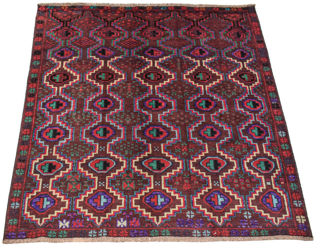 Handmade Afghan Pashm rug featuring a geometric tribal pattern in deep red, blue, and brown tones.