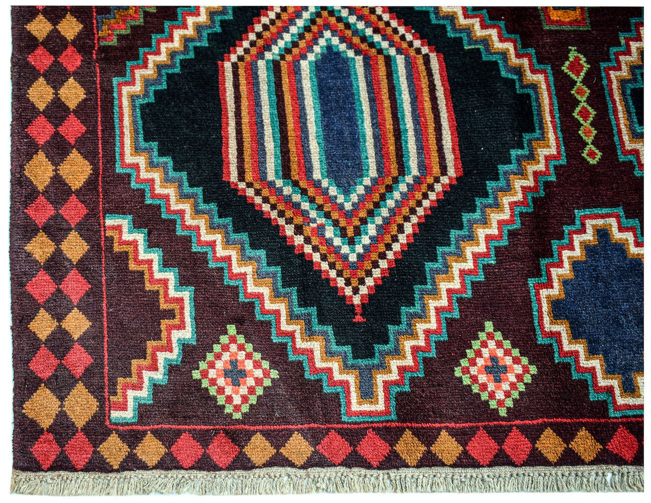 Handmade Afghan Pashm rug featuring a geometric tribal pattern in dark red, blue, and brown tones.