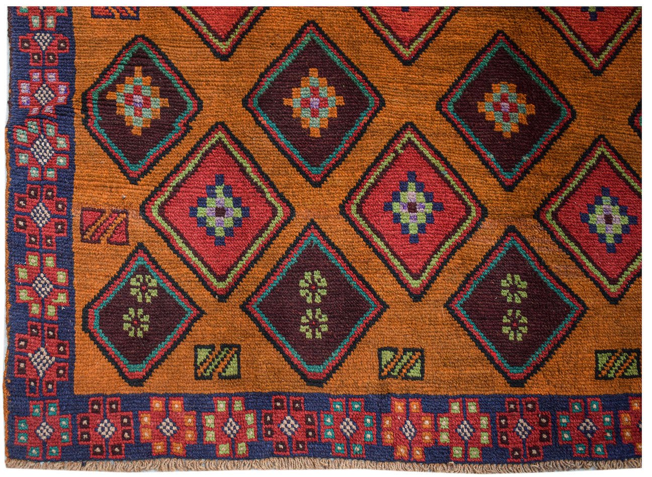 Handmade Afghan Pashm rug featuring a geometric diamond pattern in red, brown, and blue wool.