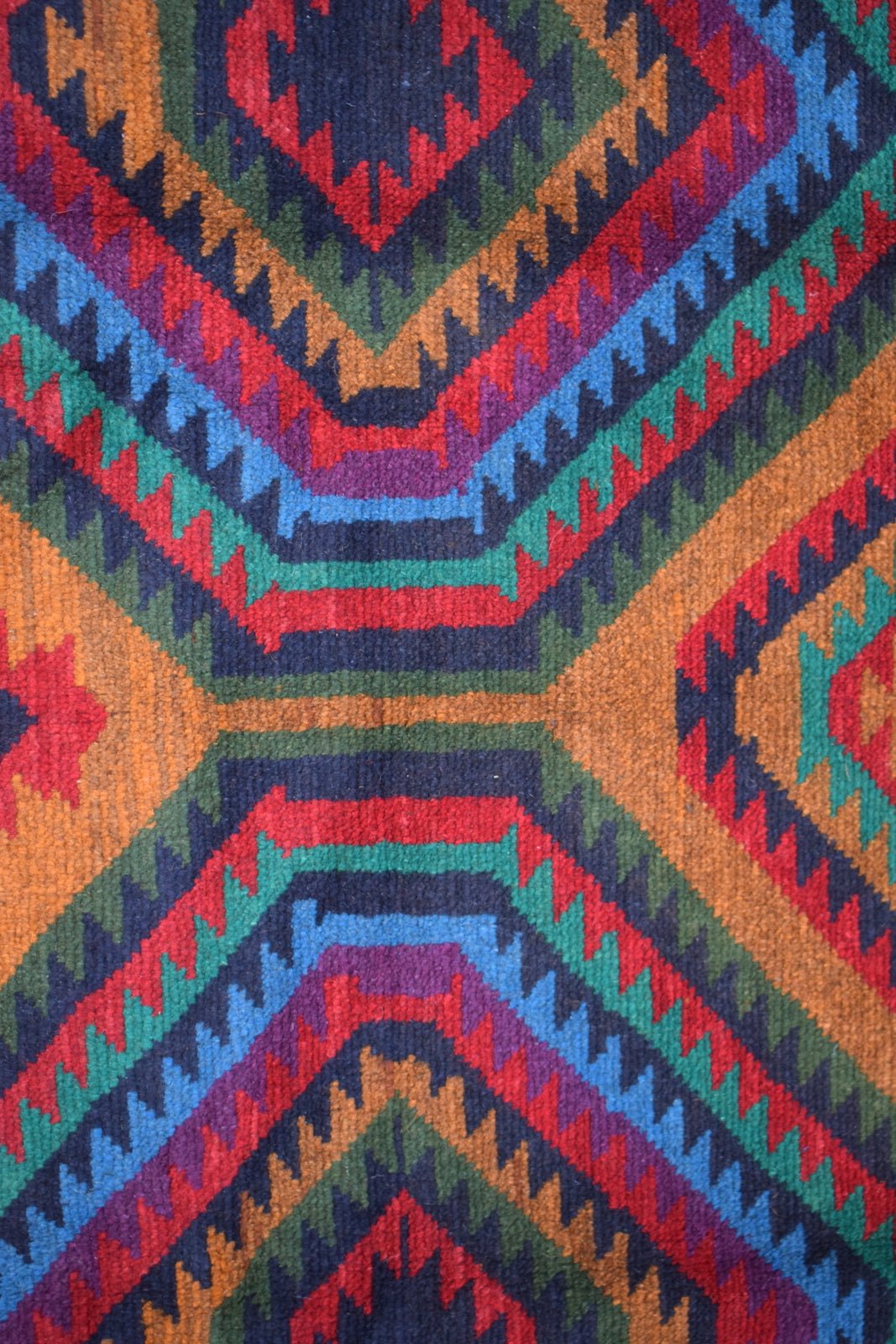 Afghan Pashm Rug with geometric patterns in red, blue, green, purple, and orange.