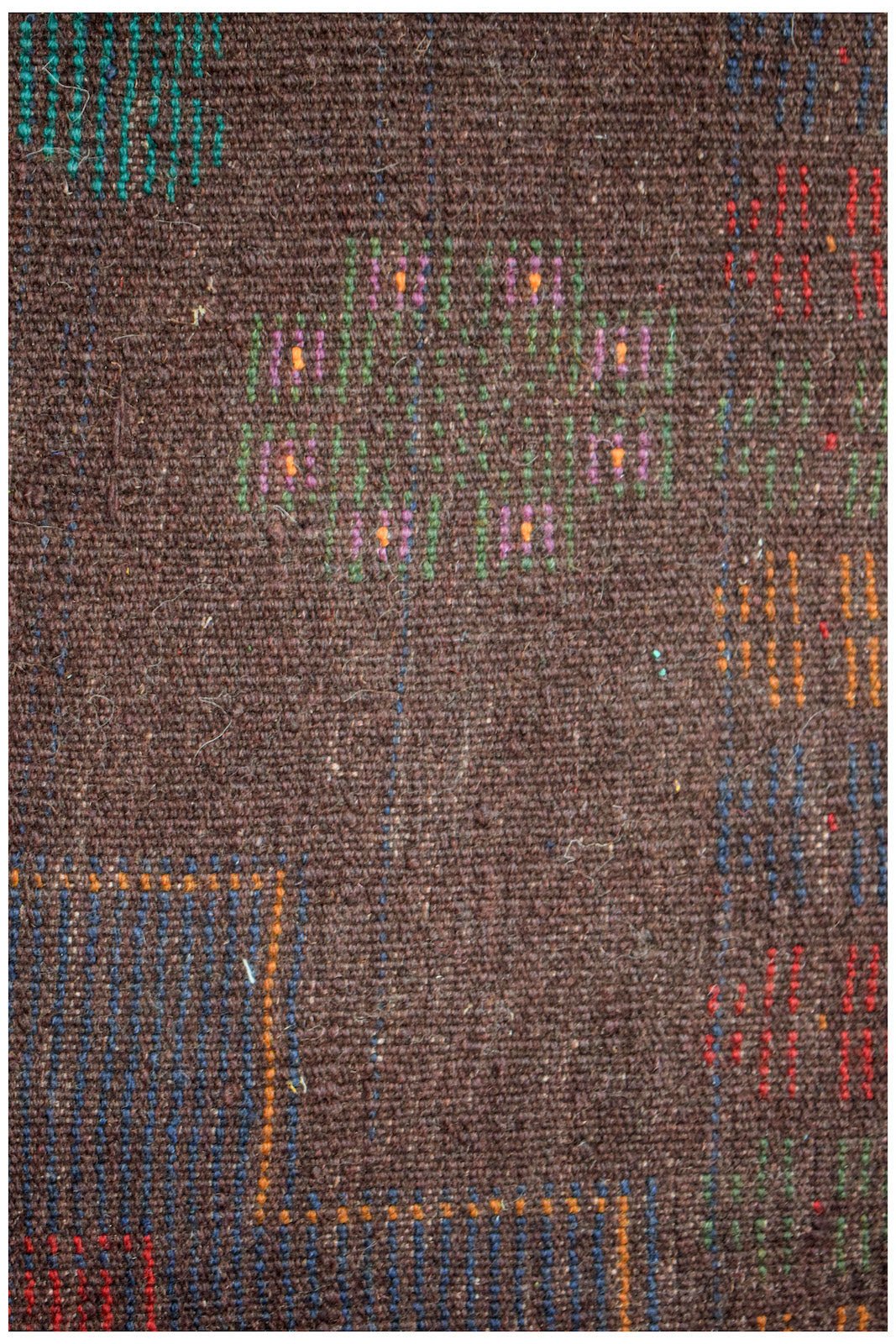 Handmade Afghan Pashm rug featuring a dark brown wool base with colorful geometric accents.