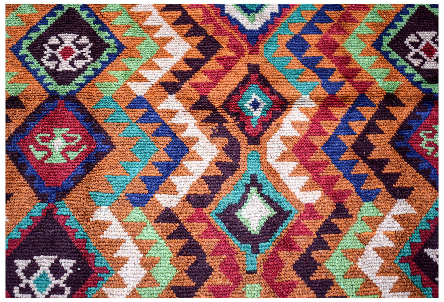 Handmade Afghan wool rug featuring a geometric diamond pattern in red, blue, and ivory tones.