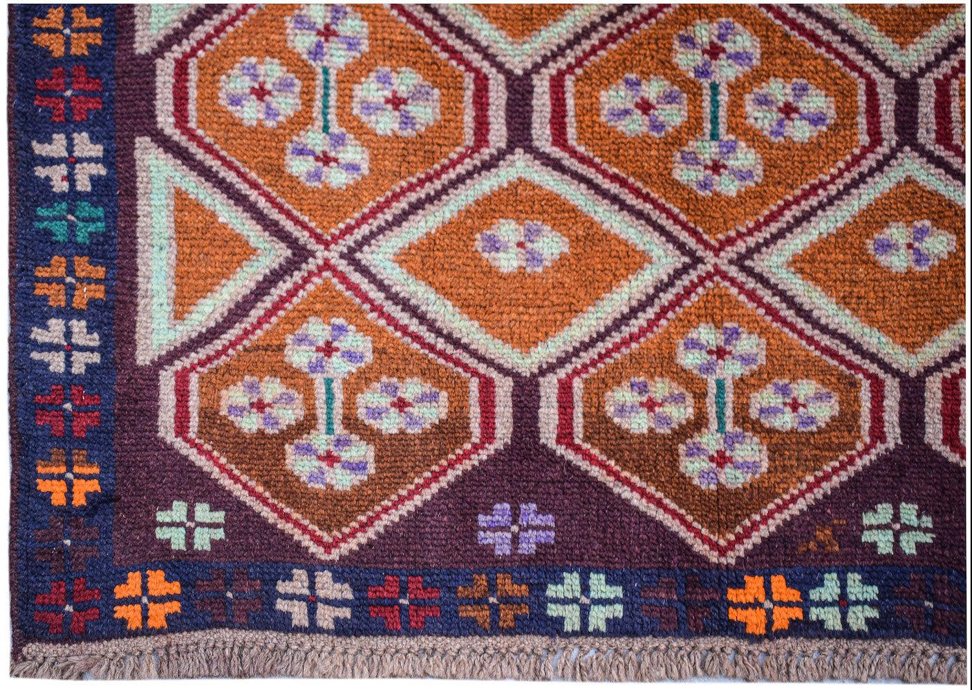 Handmade Afghan Pashm rug featuring a geometric diamond pattern in orange, brown, and blue.