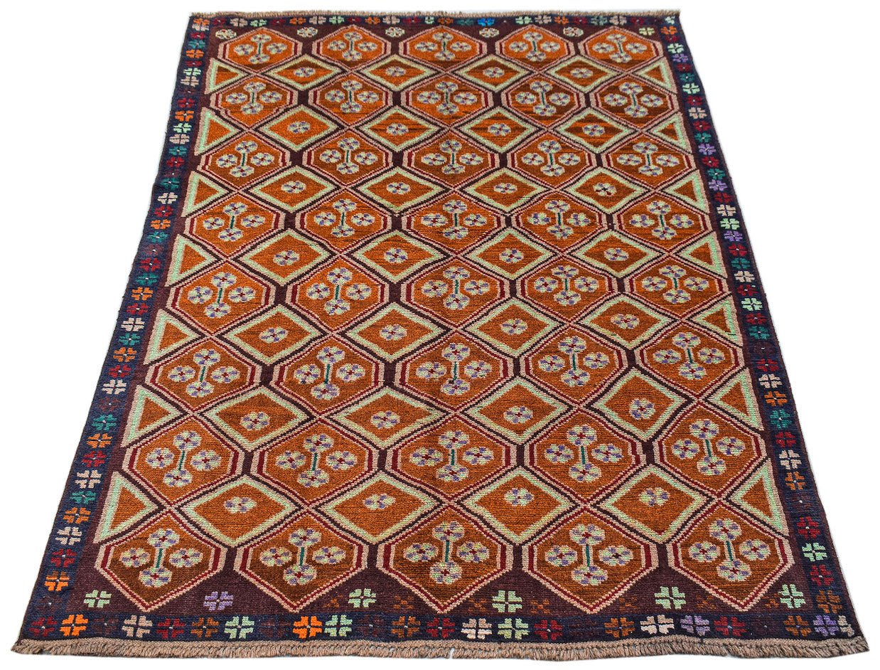 Handmade Afghan Pashm rug featuring a geometric diamond pattern in shades of brown and orange.